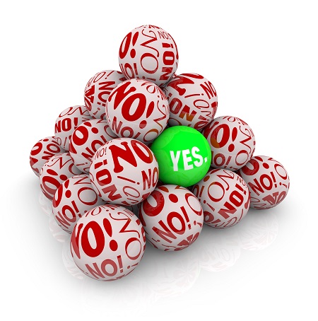 A pile of white balls covered in red “NO!” text surrounds a single bright green ball labeled “YES.” in the center, symbolizing standing out or positive thinking among negativity.